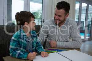 Father assisting son in his studies
