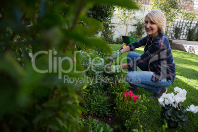 Portrait of happy woman pruning plants