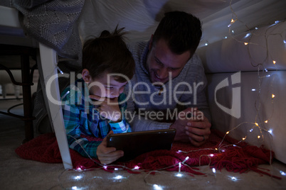 Father and son using digital tablet