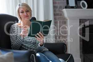 Beautiful woman reading book while having coffee