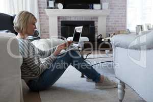 Beautiful woman using laptop in living room