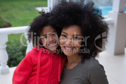 Mother and daughter smiling together in the porch