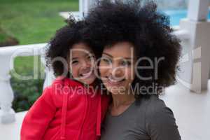 Mother and daughter smiling together in the porch