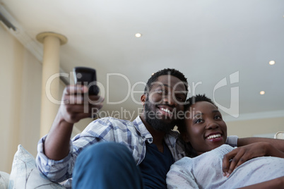 Couple watching television together in living room