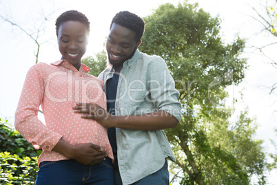 Happy couple feeling the presence of baby in stomach