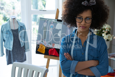 Portrait of confident female fashion designer standing with arms crossed