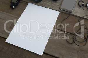 Paper with electronic device kept on wooden table