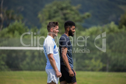 Two football players standing in the ground