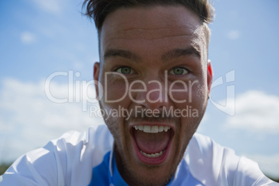 Excited football player looking at camera