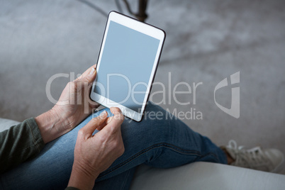 Low section of woman using digital tablet