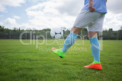 Football player juggling soccer ball