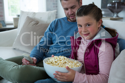 Cute girl holding bowl full of popcorn