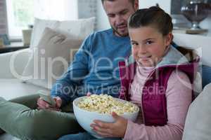 Cute girl holding bowl full of popcorn