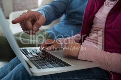 Mid section of father and daughter using laptop