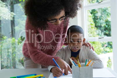 Mother helping her son in doing homework