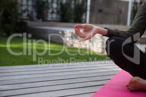 Mid section of woman practicing yoga in porch