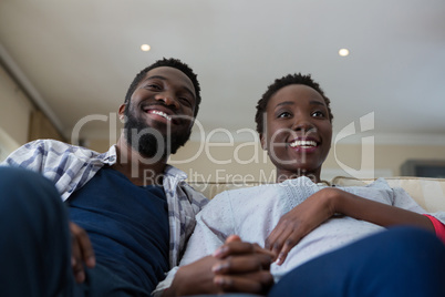 Couple watching television together in living room