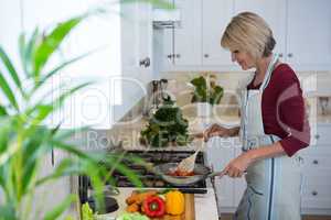 Beautiful woman cooking food in kitchen