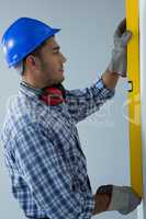 Male architect measuring wall with engineer scale