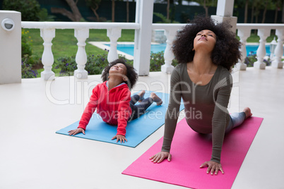 Mother and daughter exercising together in the porch
