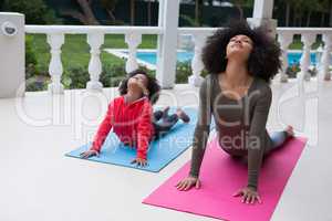 Mother and daughter exercising together in the porch