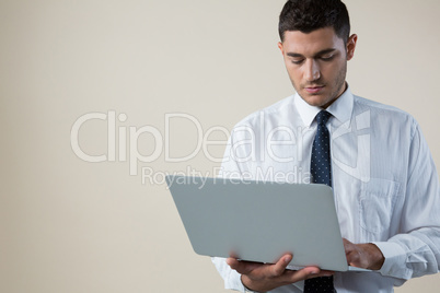 Executive using laptop against white background