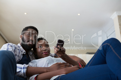 Couple watching television together in living room