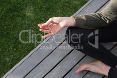 Low section of woman practicing yoga in porch