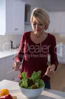 Beautiful woman preparing salad