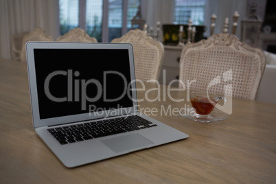 Laptop and lemon tea on dining table