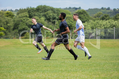 Football players playing soccer in the ground