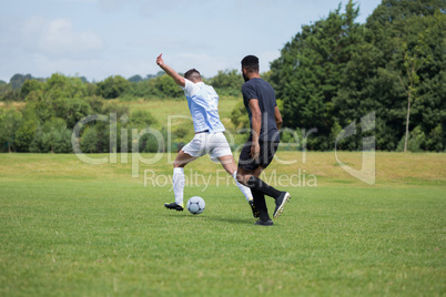 Football players playing soccer in the ground