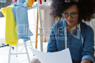 Female fashion designer looking at sketch