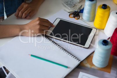 Fashion designer using digital tablet at desk
