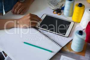Fashion designer using digital tablet at desk