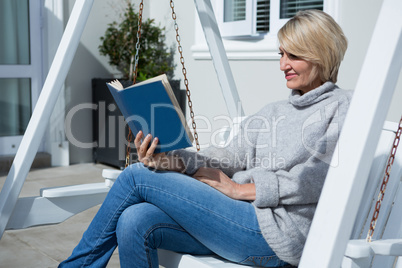 Beautiful woman reading book in porch