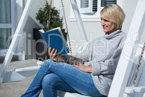 Beautiful woman reading book in porch