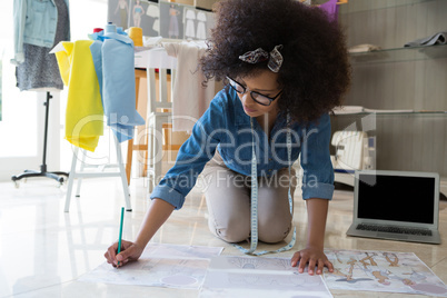 Female fashion designer drawing on paper