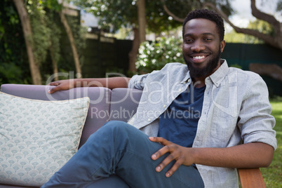 Man relaxing on sofa in garden