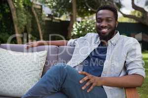 Man relaxing on sofa in garden