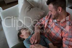 Father tickling his son in living room