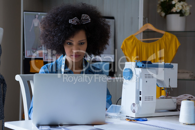Female fashion designer working on laptop