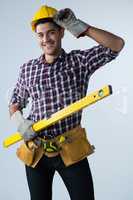 Male architect holding measuring equipment against white background