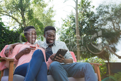 Couple using digital tablet in garden