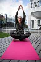 Woman practicing yoga in porch