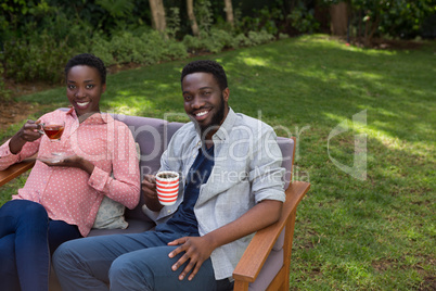 Couple having lemon tea and black coffee in garden