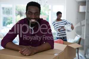 Happy man leaning on cardboard box