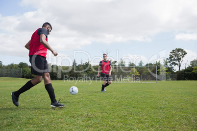 Football players playing soccer in the ground