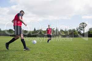 Football players playing soccer in the ground