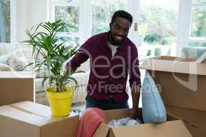 Portrait of happy man unpacking boxes